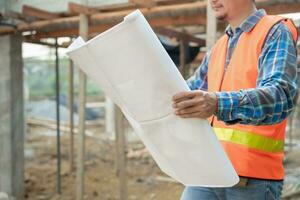 inspecteur ou ingénieur est inspecter construction et qualité assurance Nouveau maison en utilisant une bleu imprimer. ingénieur ou architectes ou contacteur travail à construire le maison avant remise il plus de à le propriétaire photo