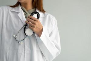 une femme médecin tient un stéthoscope et entend le son des battements cardiaques