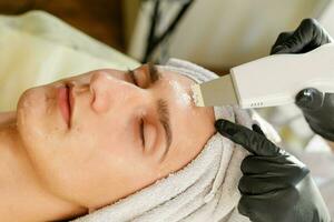 le cosmétologue fait du le procédure ultrasonique visage peeling photo