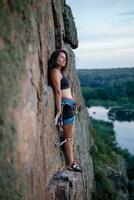 une fille grimpe une rock. femme engagé dans extrême sport. photo