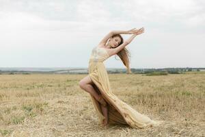 femme en marchant dans d'or séché herbe champ. photo