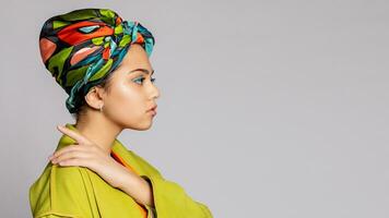 portrait de une Jeune femme avec brillant maquillage et une à la mode foulard. photo