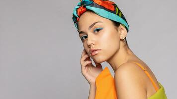 portrait de une Jeune femme avec brillant maquillage et une à la mode foulard. photo