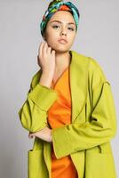 portrait de une Jeune femme avec brillant maquillage et une à la mode foulard. photo