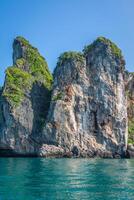 falaise et le clair mer avec une bateau près phi phi île dans Sud de Thaïlande photo