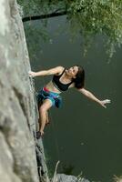 une fille grimpe une rock. femme engagé dans extrême sport. photo