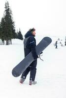 snowboarder dans casque permanent à le très Haut de une Montagne photo