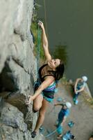 une fille grimpe une rock. femme engagé dans extrême sport. photo