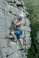 une fille grimpe une rock. femme engagé dans extrême sport. photo