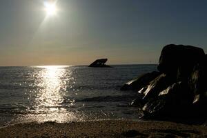 le coucher du soleil plage dans cap mai Nouveau Jersey où vous pouvez avoir une génial vue de le Soleil Aller vers le bas à travers le océan et le baie. le réflexion de le Soleil sur le l'eau avec le creux navire regards donc belle. photo