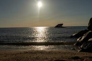 le coucher du soleil plage dans cap mai Nouveau Jersey où vous pouvez avoir une génial vue de le Soleil Aller vers le bas à travers le océan et le baie. le réflexion de le Soleil sur le l'eau avec le creux navire regards donc belle. photo