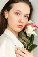 Jeune magnifique femme odeur une bouquet de rouge des roses photo