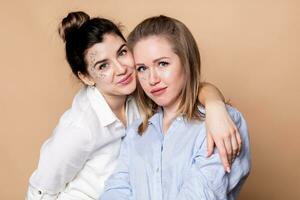 portrait de deux content femmes dans noir et blanc vêtements souriant photo