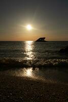 le coucher du soleil plage dans cap mai Nouveau Jersey où vous pouvez avoir une génial vue de le Soleil Aller vers le bas à travers le océan et le baie. le réflexion de le Soleil sur le l'eau avec le creux navire regards donc belle. photo