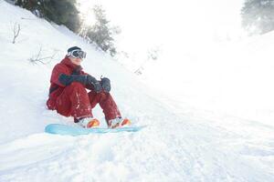 snowboarder est assis haute dans le montagnes photo
