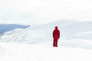 snowboarder des stands sur arrière-pays pente et détient snowboard. photo