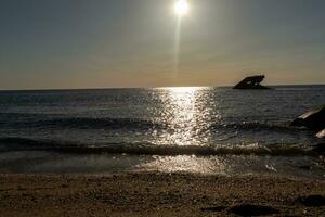 le coucher du soleil plage dans cap mai Nouveau Jersey où vous pouvez avoir une génial vue de le Soleil Aller vers le bas à travers le océan et le baie. le réflexion de le Soleil sur le l'eau avec le creux navire regards donc belle. photo