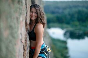 une fille grimpe une rock. femme engagé dans extrême sport. photo