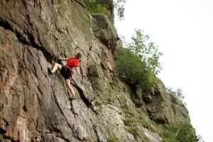 une fille grimpe une rock. femme engagé dans extrême sport. photo