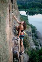 une fille grimpe une rock. femme engagé dans extrême sport. photo