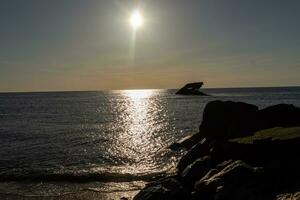 le coucher du soleil plage dans cap mai Nouveau Jersey où vous pouvez avoir une génial vue de le Soleil Aller vers le bas à travers le océan et le baie. le réflexion de le Soleil sur le l'eau avec le creux navire regards donc belle. photo