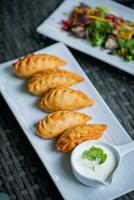 frit Empanadas avec acide crème et salade sur en bois table photo