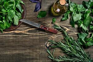 variété de Frais biologique herbes sur en bois Contexte. fraîchement récolté herbes comprenant basilic, Romarin. Haut voir. copie espace. photo