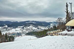 panorama de ski station balnéaire, pente, gens sur le ski ascenseur, skieurs sur le piste parmi vert pin des arbres et neige lances. photo