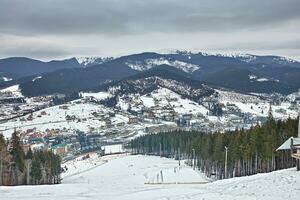 panorama de ski station balnéaire, pente, gens sur le ski ascenseur, skieurs sur le piste parmi vert pin des arbres et neige lances. photo