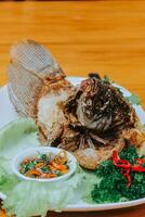 Profond frit gourami poisson servi Chili sauce isolé sur blanc Contexte photo