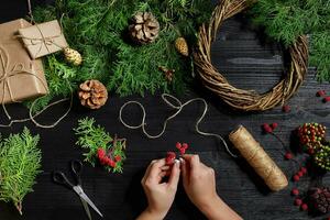 fabricant de Noël décor avec leur posséder mains. Noël couronne pour le vacances. le Nouveau année fête. Haut vue photo