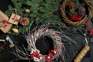 fabricant de Noël décor avec leur posséder mains. Noël couronne pour le vacances. le Nouveau année fête. Haut vue photo