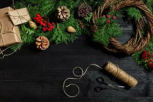 fabricant de Noël décor avec leur posséder mains. Noël couronne pour le vacances. le Nouveau année fête. Haut vue photo