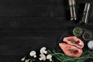 poulet Sein sur une Coupe planche avec herbes et différent des légumes sur rustique en bois Contexte. photo