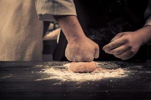 le chef fait du pâte pour Pâtes sur une en bois table photo