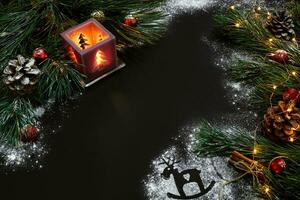 Noël, Noël arbre, bougie, neige, cônes et cannelle des bâtons sur noir Contexte photo