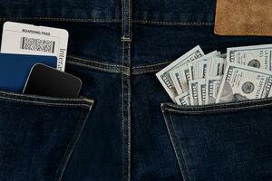 dollars, intelligent, passeport et avion billet dans votre poche jeans. photo