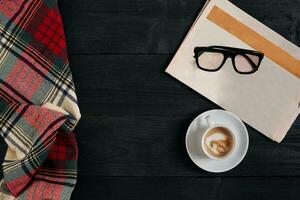 espace de travail avec journal, café tasse, foulard, lunettes. élégant Bureau bureau. l'automne ou hiver concept. plat poser, Haut vue photo