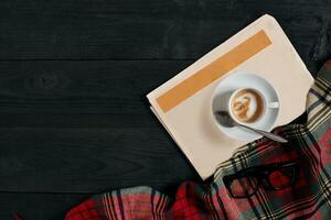 espace de travail avec journal, café tasse, foulard, lunettes. élégant Bureau bureau. l'automne ou hiver concept. plat poser, Haut vue photo