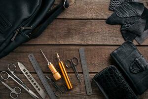 cuir artisanat ou cuir fonctionnement. cuir travail outils et Couper en dehors pièces de cuir sur travail bureau . photo