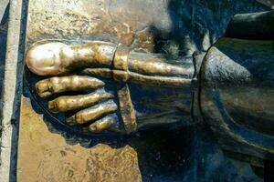 une bronze statue de une pied avec une Balle sur il photo