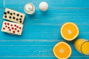 en bonne santé petit déjeuner. sucré des sandwichs avec crème fromage et Frais baies et fruit sur bleu Contexte. photo