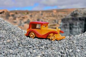 une jouet voiture est assis sur Haut de une pile de rochers photo