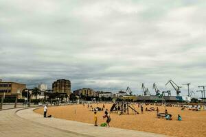 gens sont profiter le plage sur une nuageux journée photo