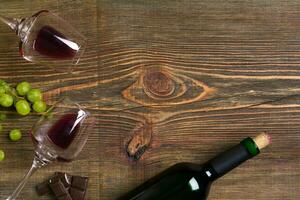 deux lunettes, bouteille de rouge du vin et grain de raisin sur une en bois table photo