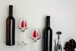 des lunettes et bouteilles de rouge et blanc du vin sur blanc Contexte de Haut vue photo