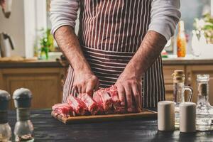 homme coupes de Frais pièce de Viande sur une en bois Coupe planche dans le Accueil cuisine photo