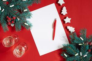 rouge stylo et bloc-notes sur rouge table décoré avec une sapin branche. le Contexte pour le texte. photo