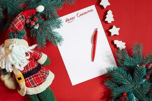 rouge stylo et bloc-notes sur rouge table décoré avec une sapin branche. le Contexte pour le texte. photo