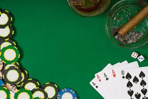 jeu, fortune et divertissement concept - proche en haut de casino puces, whisky verre, en jouant cartes et cigare sur vert table surface photo